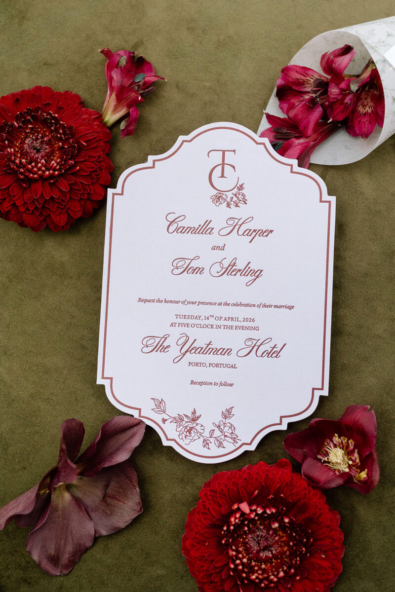 Convite de casamento no The Yeatman em papel branco com letterpress bordeaux e monograma, rodeado de dálias bordeaux sobre veludo verde